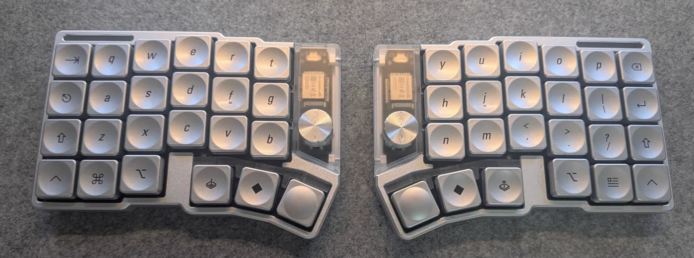 Top-down view of both halves of a silver split keyboard with dished metallic silver keycaps